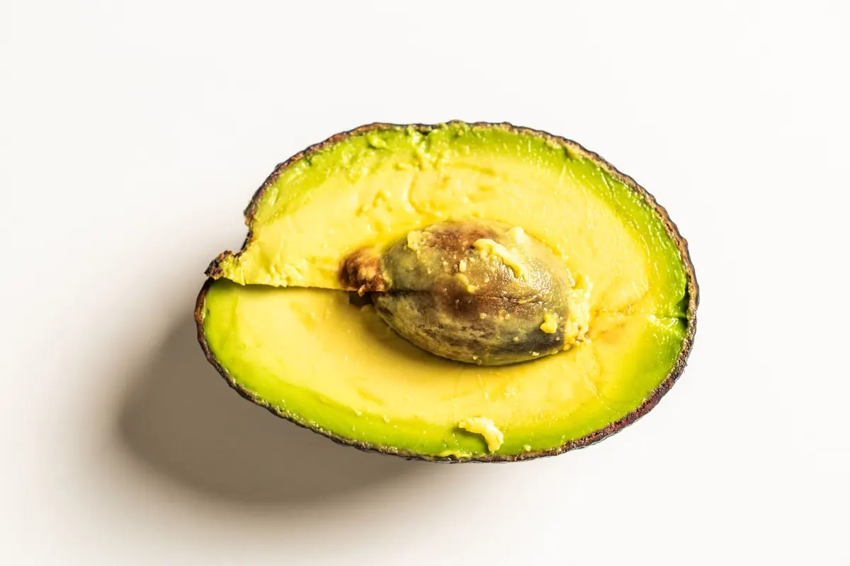Half an avocado on white
