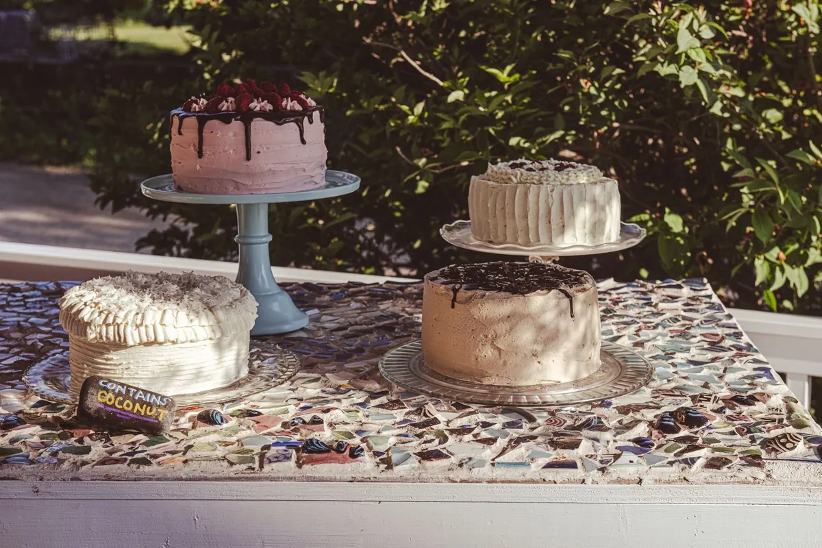 Three layer cakes on a mosaic patio table